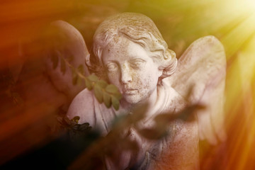 Vintage image of a sad angel. Ancient white statue. Religion, faith, death, eternity concept