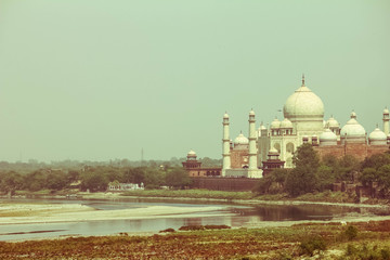 Fototapeta na wymiar Cross processed vintage retro effect photo of Taj Mahal near yamuna river, Agra, India