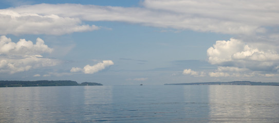 Obraz premium Sailboat between Bainbridge island and Shoreline