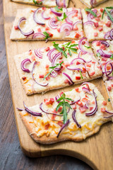 Flammkuchen - Traditional French dish tarte flambee cream cheese, bacon and onions