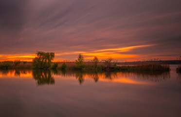 Long exposure sunset view on Ivano-Frankove Yaniv , Yanivskyi Stav Lake and forest. Roztochia Biosphere Reserve, Lviv district, Ukraine. May 2020