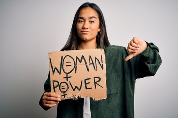 Beautiful activist asian woman asking for women rights holding banner with power message with angry...