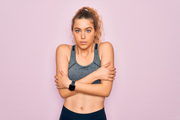 Fototapeta na wymiar Young beautiful blonde sportswoman with blue eyes doing exercise wearing sportswear shaking and freezing for winter cold with sad and shock expression on face
