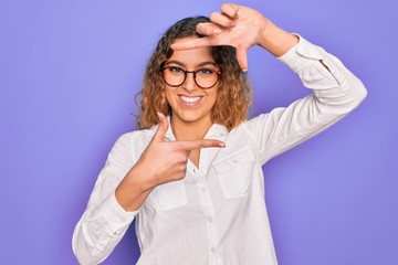 Young beautiful woman with blue eyes wearing casual shirt and glasses over purple background smiling making frame with hands and fingers with happy face. Creativity and photography concept.