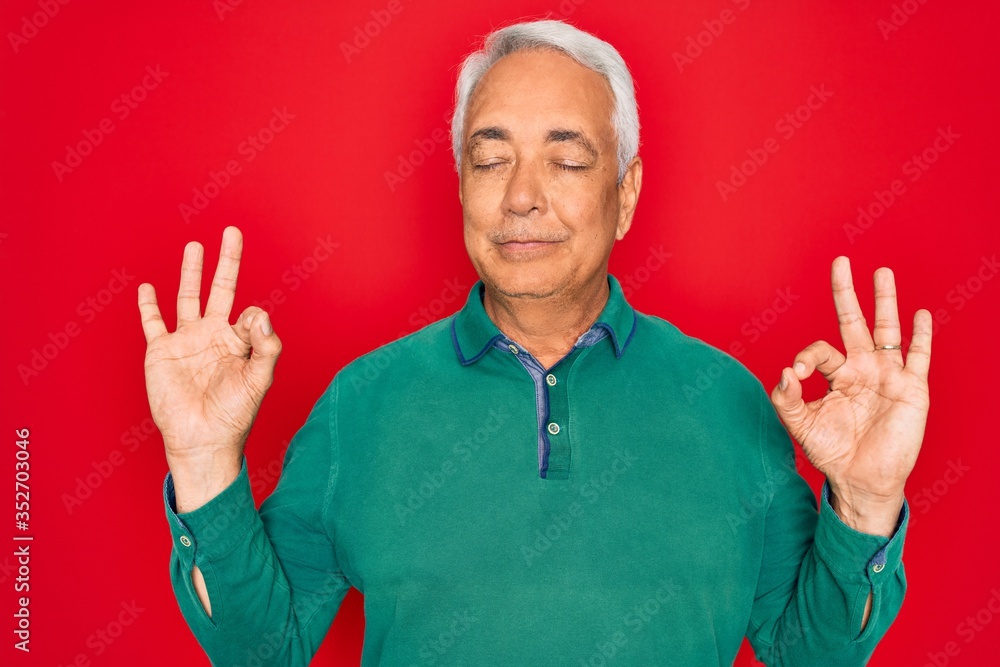 Poster Middle age senior grey-haired man wearing casual sweater over red isoalted background relax and smiling with eyes closed doing meditation gesture with fingers. Yoga concept.