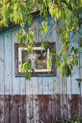 Blue pastel texture of old wooden hut with a window. Selective focus. 
