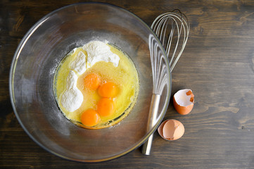 A transparent bowl with eggs and flour. Cooking cake. Selective focus.