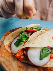 Making cooking of tacos with meat sauce cilantro and radish