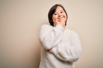 Young down syndrome woman standing over isolated background looking confident at the camera smiling with crossed arms and hand raised on chin. Thinking positive.