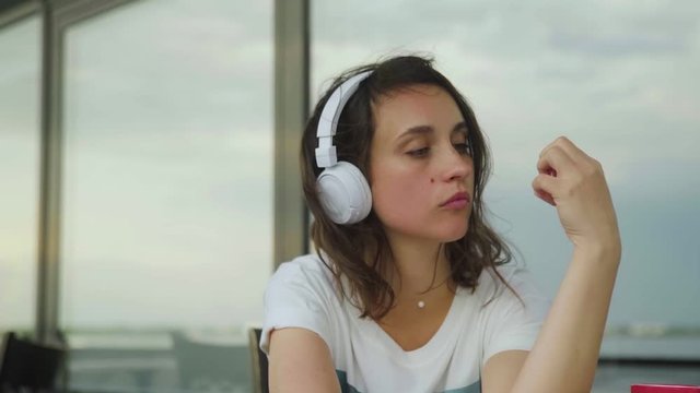 Young depressive woman in headphones listening to music