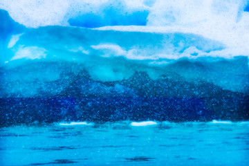 Fototapeta na wymiar Snowing Floating Blue Iceberg Reflection Paradise Bay Skintorp Cove Antarctica