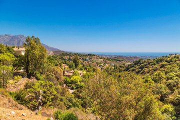 view of a beautiful hillside with the sea and mountains