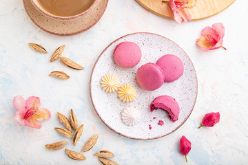 Purple macarons or macaroons cakes with cup of coffee on a white concrete background. Top view,...