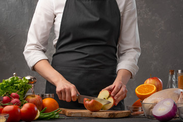 Chef cuts apples for cooking a duck or chicken. Recipe book, home recipes