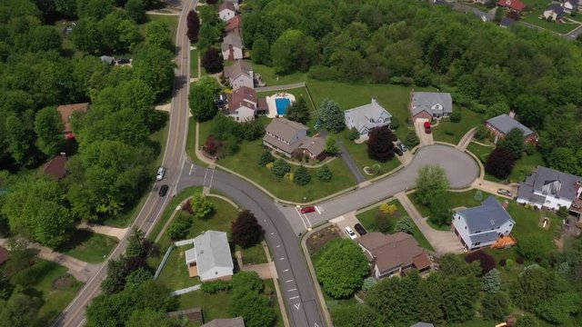 A high angle summer aerial flyover establishing shot of a typical Western Pennsylvania residential neighborhood. Pittsburgh suburbs.  	