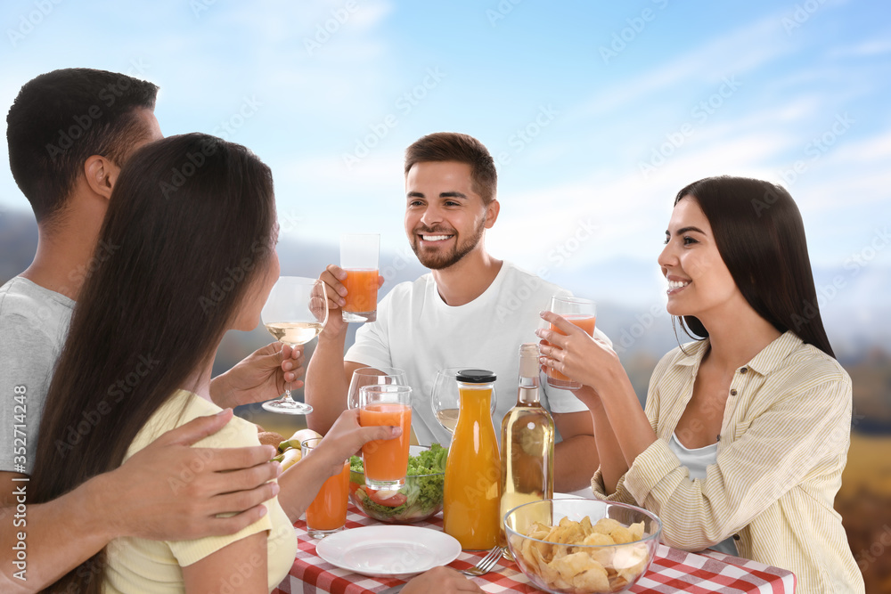 Sticker Group of friends having picnic at table in park