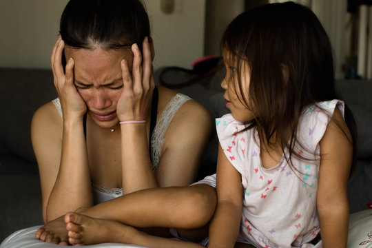 Stressed unhappy mother at home with her child.