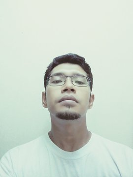 Low Angle Portrait Of Young Man Against White Background