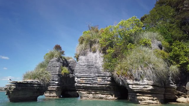 4K hand held stationary motion of the rock formations know as the Pancake Rocks on the west coastline at the town of Raglan, popular for leisure kayakers and paddleborders,North island,New Zealand  