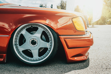 Tuned red sport car wheel, close up. Low rider sport auto. - obrazy, fototapety, plakaty