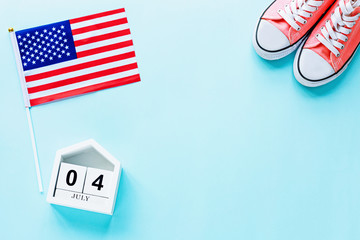 July 4th. Mockup of july 4 wooden color calendar and USA flag on blue background. Copy space for text. Independence Day Of America. Flat lay, top view, template