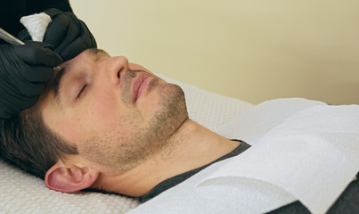 Close up of cosmetologist making permanent makeup. Microblading procedure. High quality close-up of...
