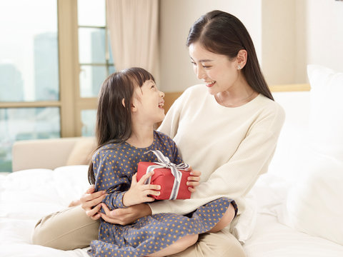 asian mother giving present to daughter