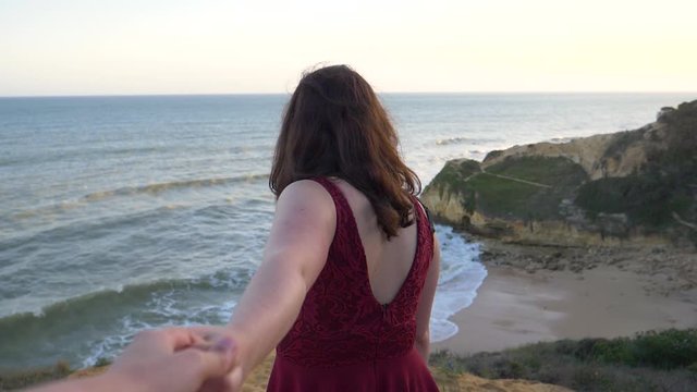 Lesbian couple holding hands at beach sunset, Algarve, Portugal. Follow me POV.