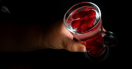 
Raspberries in a water glass. Free entry space.