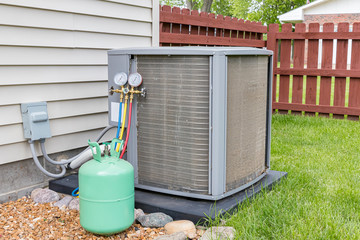 Dirty air conditioning unit. Condenser coils full of dirt and grass debris. Freon charging tools....