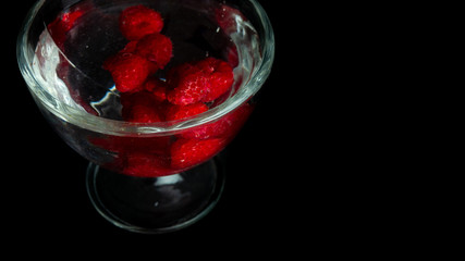 
Raspberries in a water glass. Free entry space.