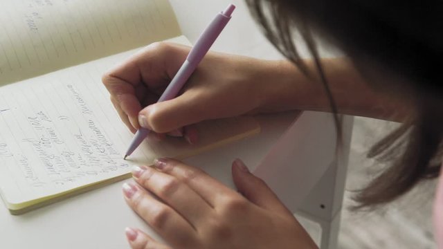 Close up woman hand write notes with pen in notebook