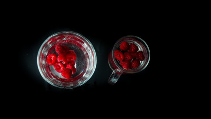 
Raspberries in glasses of water. Free space for entry.