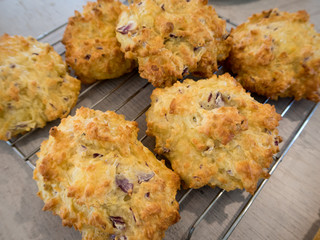 Freshly baked homemade cheese puffs for lunch boxes cool on a wire rack on a kitchen benchtop
