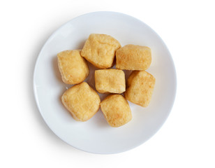 Top view of  brown tofu puff with plate isolated on white.
