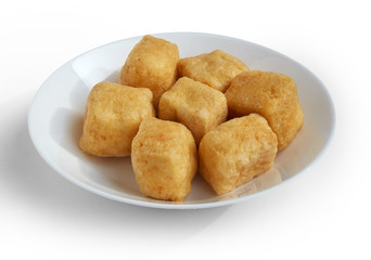 Group of brown tofu puff with plate isolated on white.