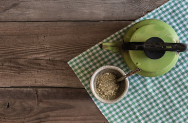 mate and kettle, traditional Argentine yerba mate infusion, on rustic wooden background