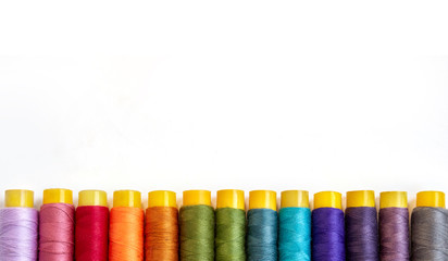 Top view of color sewing threads on white background