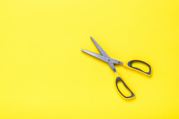 Yellow kitchen scissors on a yellow background. Flat lay.