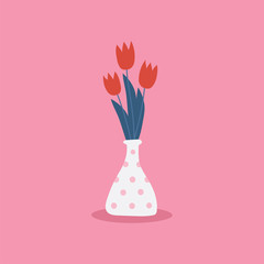 Bouquet of red tulip flowers in polka dot vase isolated on pink background.