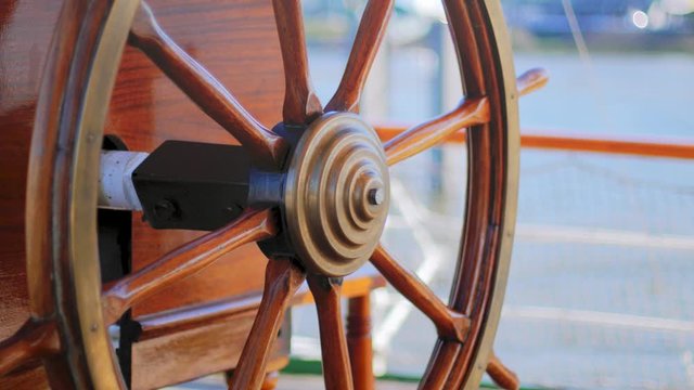 Close up of an old wodden ship's steering wheel of a traditional european sailing ship Rickmer Rickmers from the 19th century. Camera panning movement.