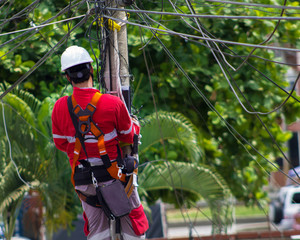
man doing electrical work on power pole