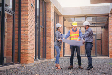Structural engineer and architect working with blueprints discuss at the building structure,...