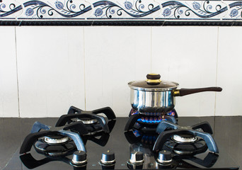 
lighted stove with pot preparing food in kitchen