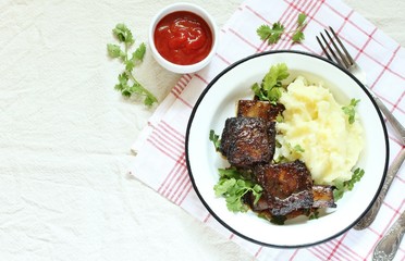 baked short ribs with mashed potatoes.
long stewed meat. rustic style, linen tablecloth, top view, copy space