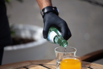 man with gloves serving drinks