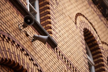 siren loudspeakers on brick wall