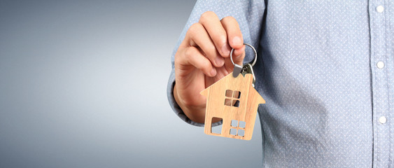 Real estate agent handing over house keys in hand