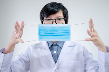 Male Asian doctor or Physician man showing how to wear surgical mask in hospital. Coronavirus...