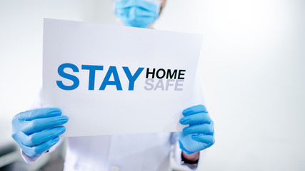 Male Asian Doctor or Physician man wearing surgical mask and gloves showing paper with message...